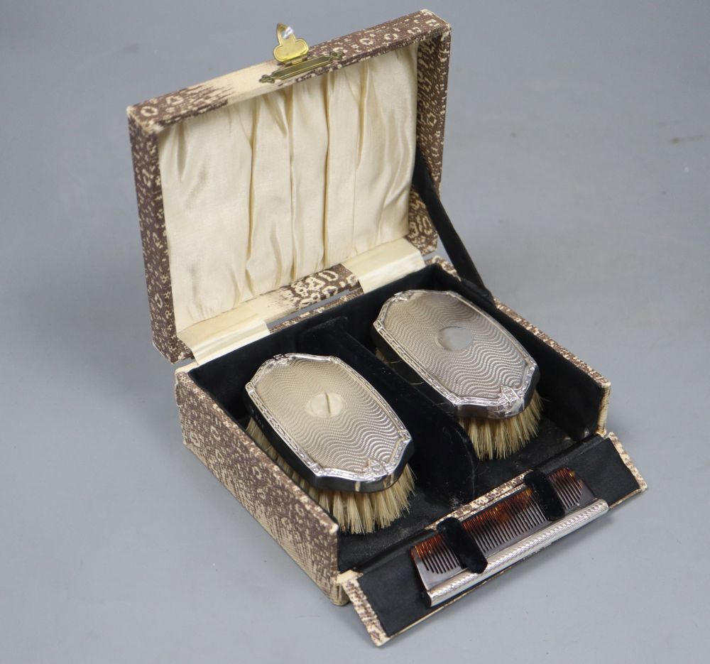 A cased pair of George V silver mounted brushes and matching comb, Birmingham, 1927.
